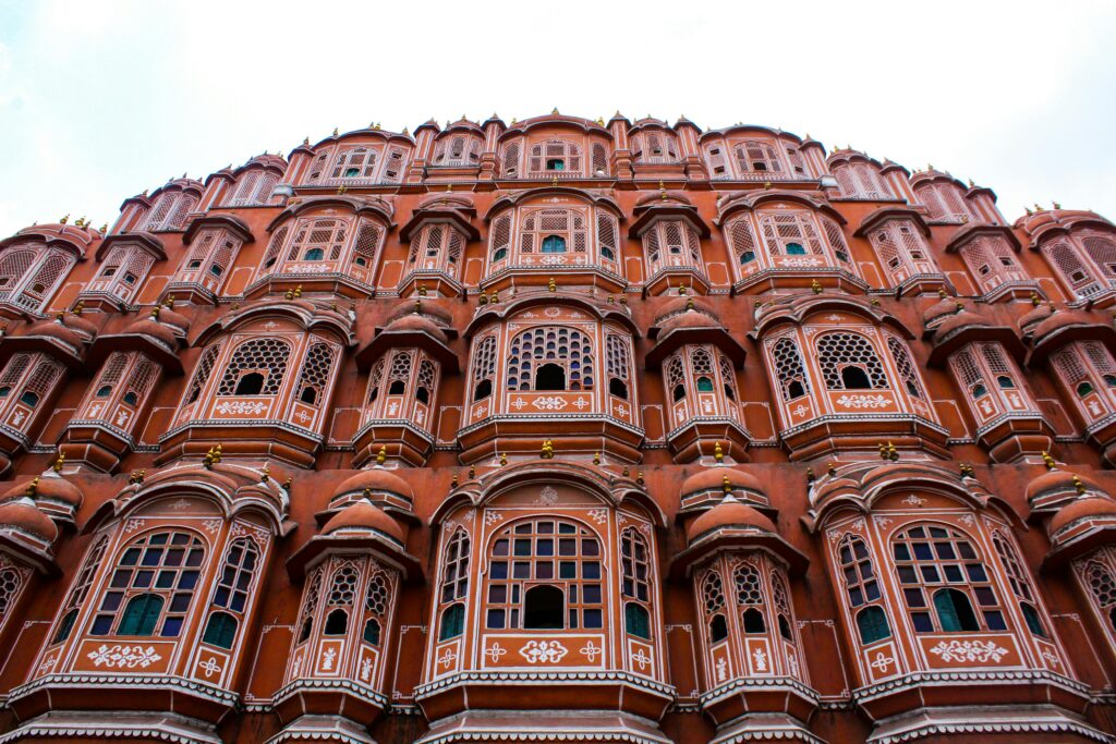 Low angle view of the iconic Hawa Mahal showcasing its elaborate facade in Jaipur, India.